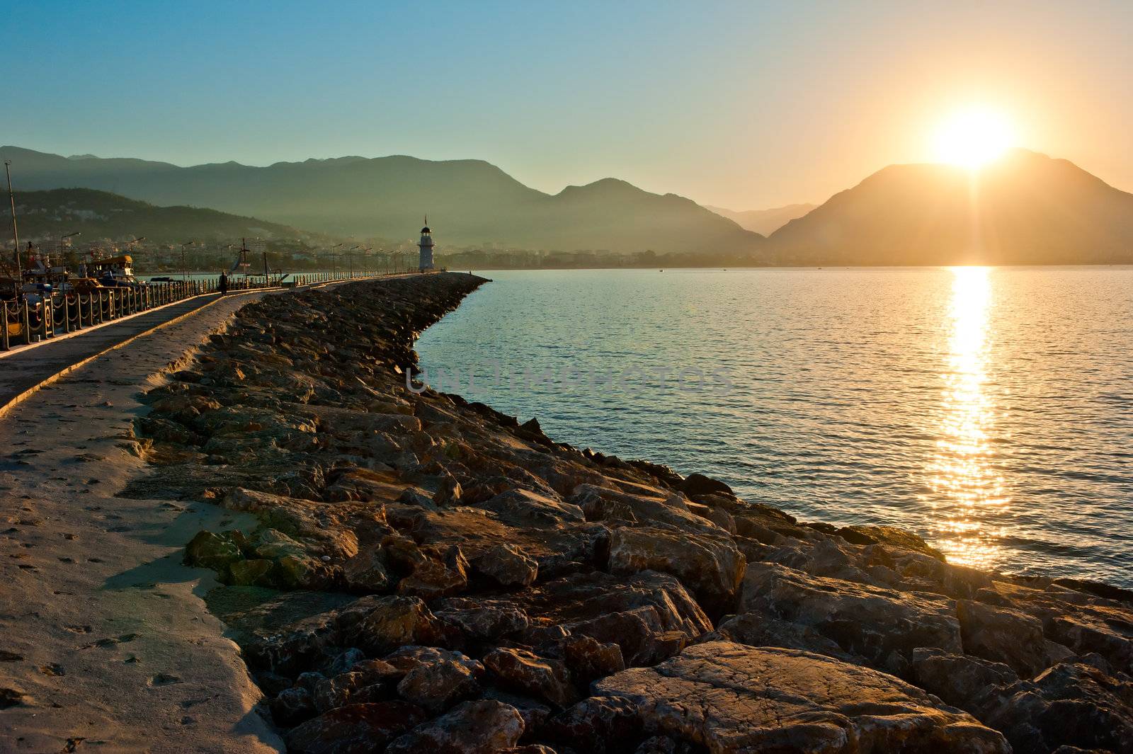 Landscape with a lighthouse in the harbor town of Alanya at dawn. by kosmsos111