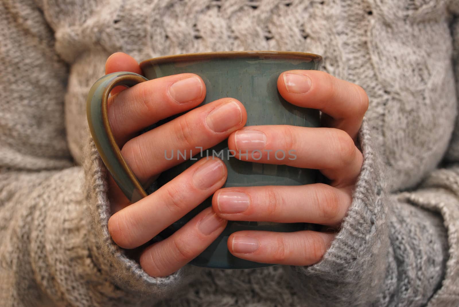 Closeup of a woman's hands holding a mug of drink