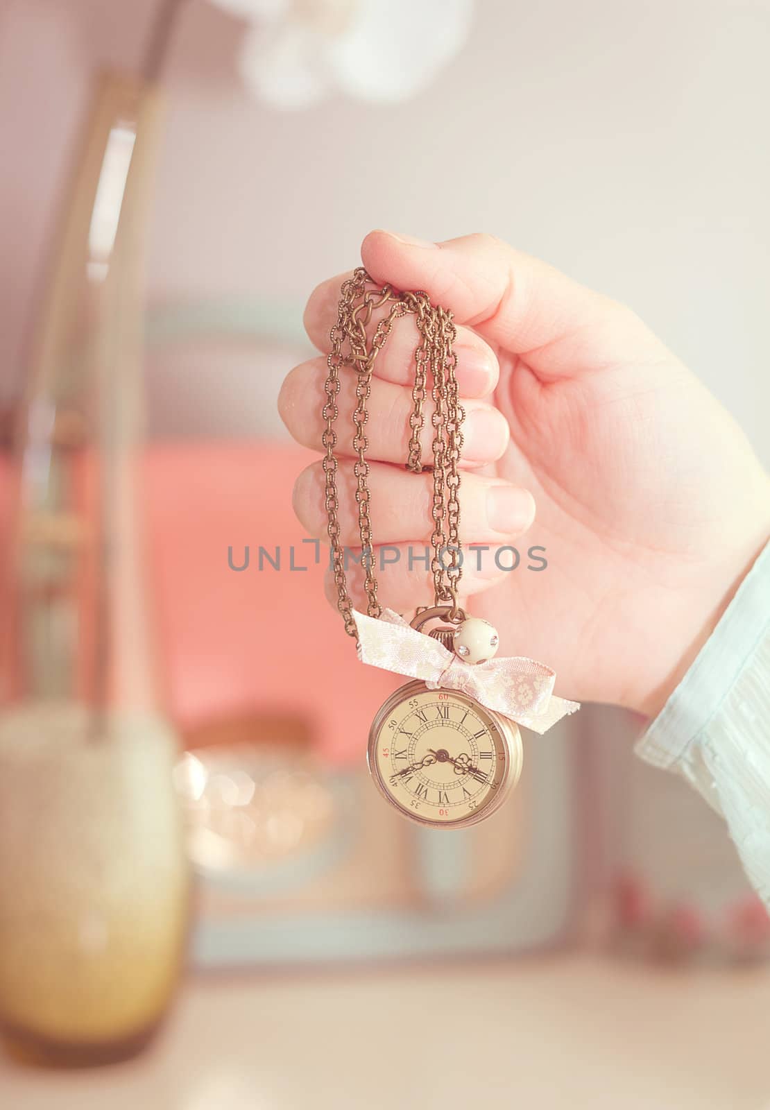 Girl hand holding a vintage clock necklace in front of female co by doble.d