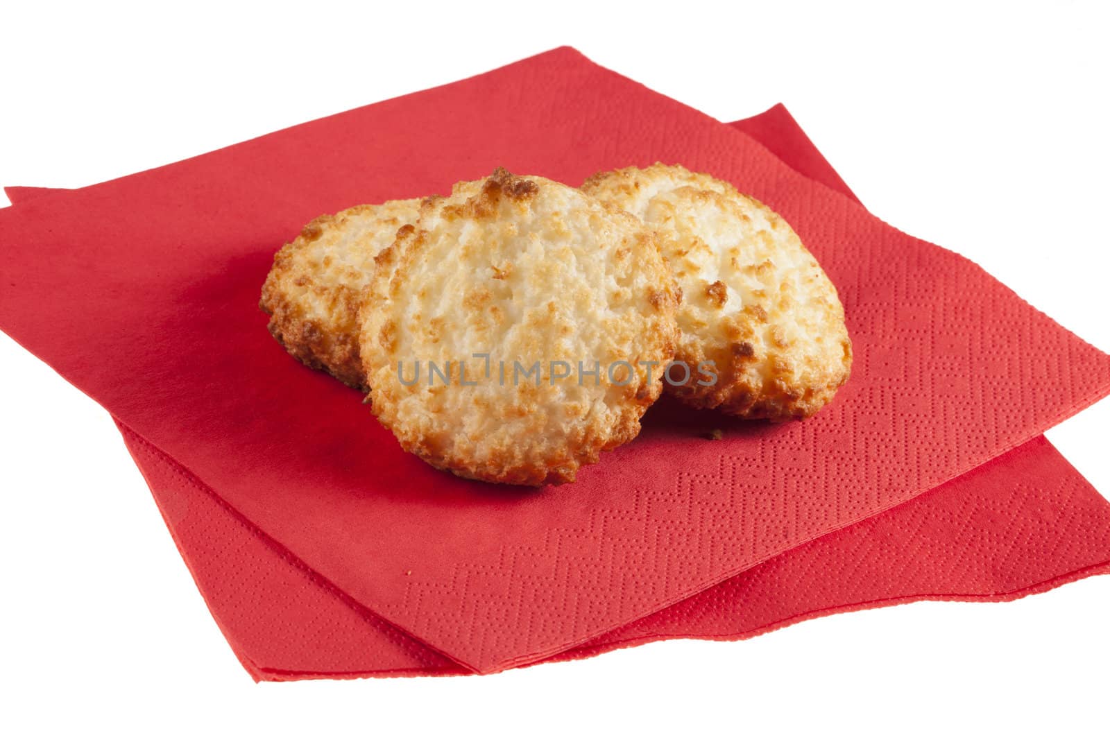 Three macaroons on red napkins with white background,