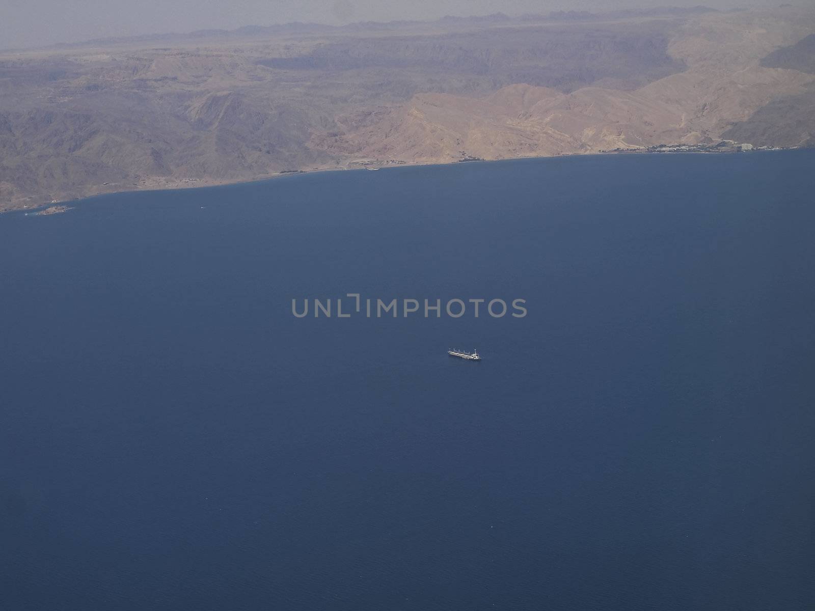 Aerial view of an oil tanker in the Red Sea desert with mountains in the background