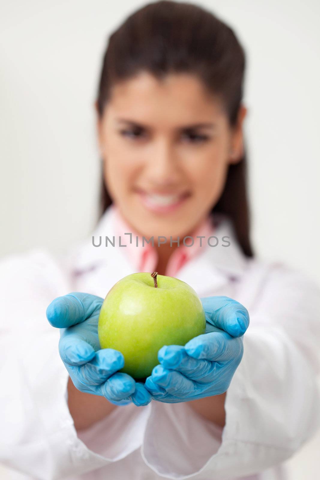 Doctor holding a green apple by leaf