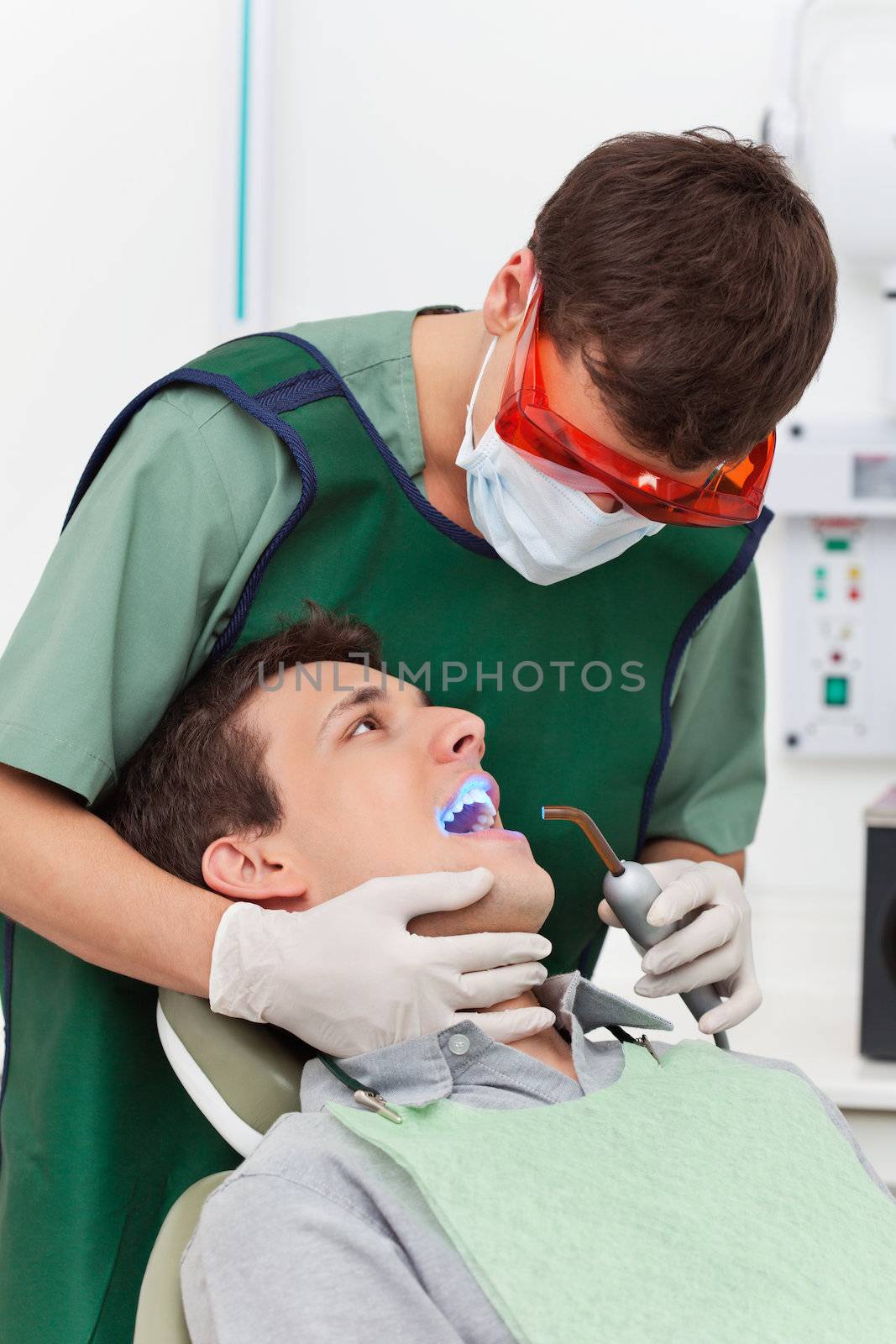Young man going through therapy of tooth in clinic