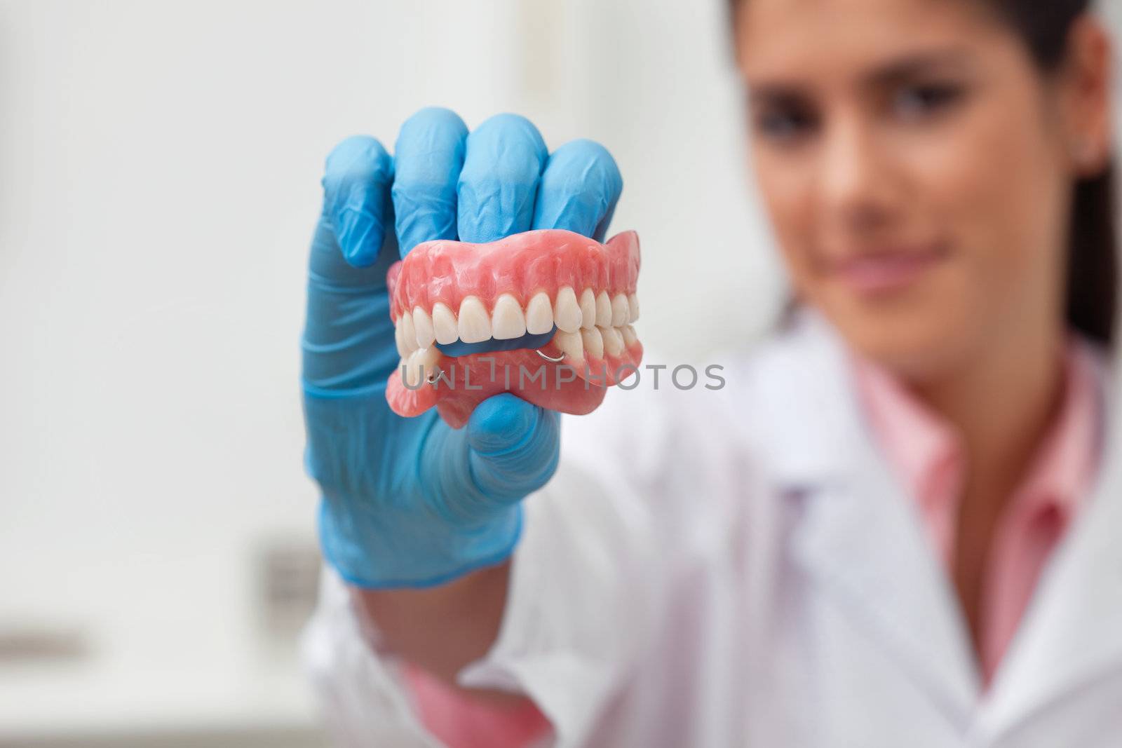 Female dentist holding dental mold by leaf