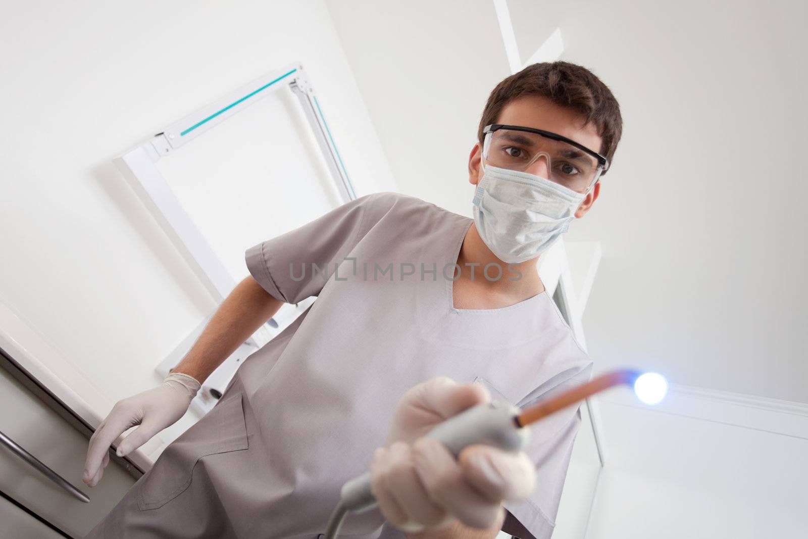 Dentist wearing mask holding medical equipment