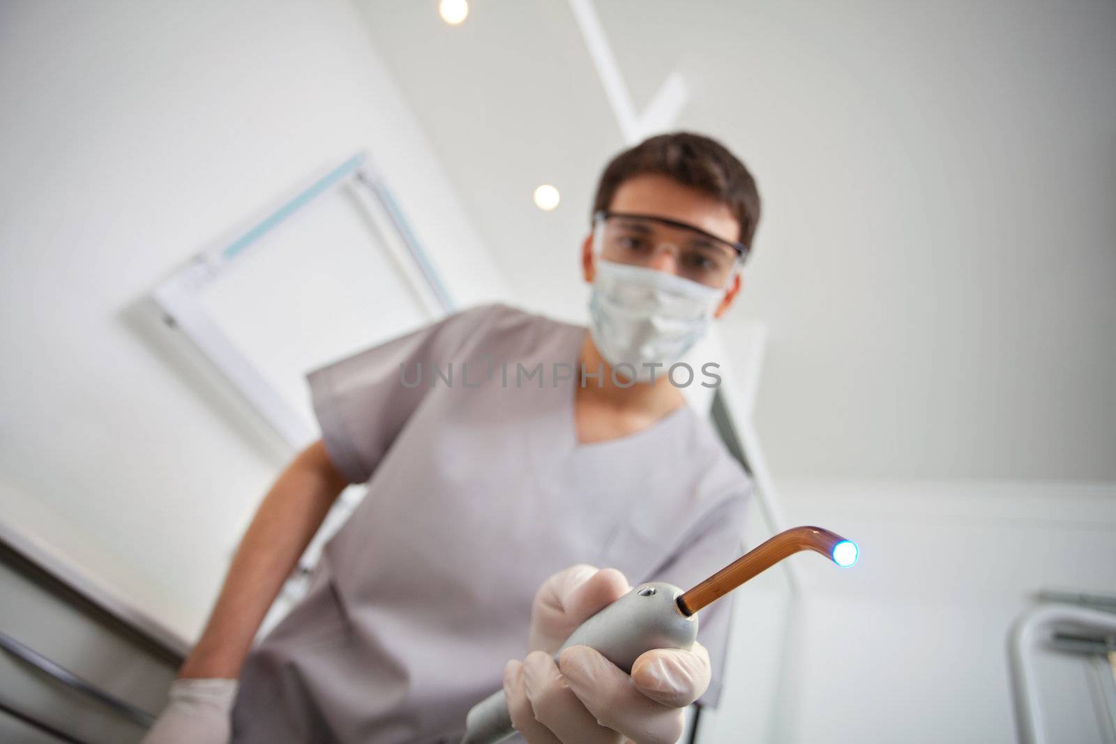 Low angle view of male dentist holding ultraviolet light