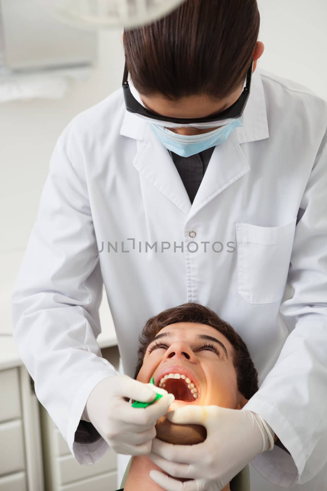 Male patient having his teeth examined by female specialist