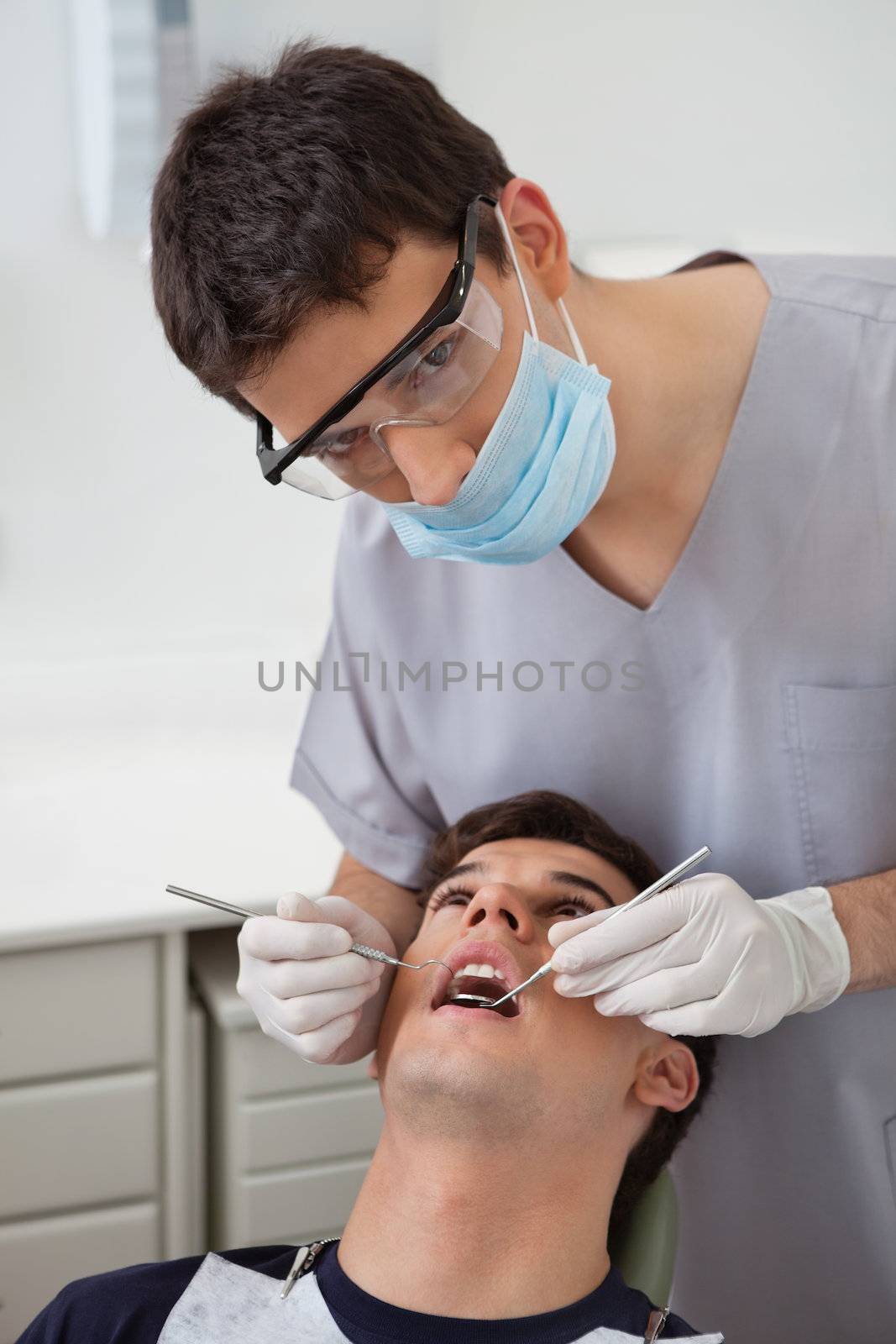 Dentist examining patient's teeth by leaf