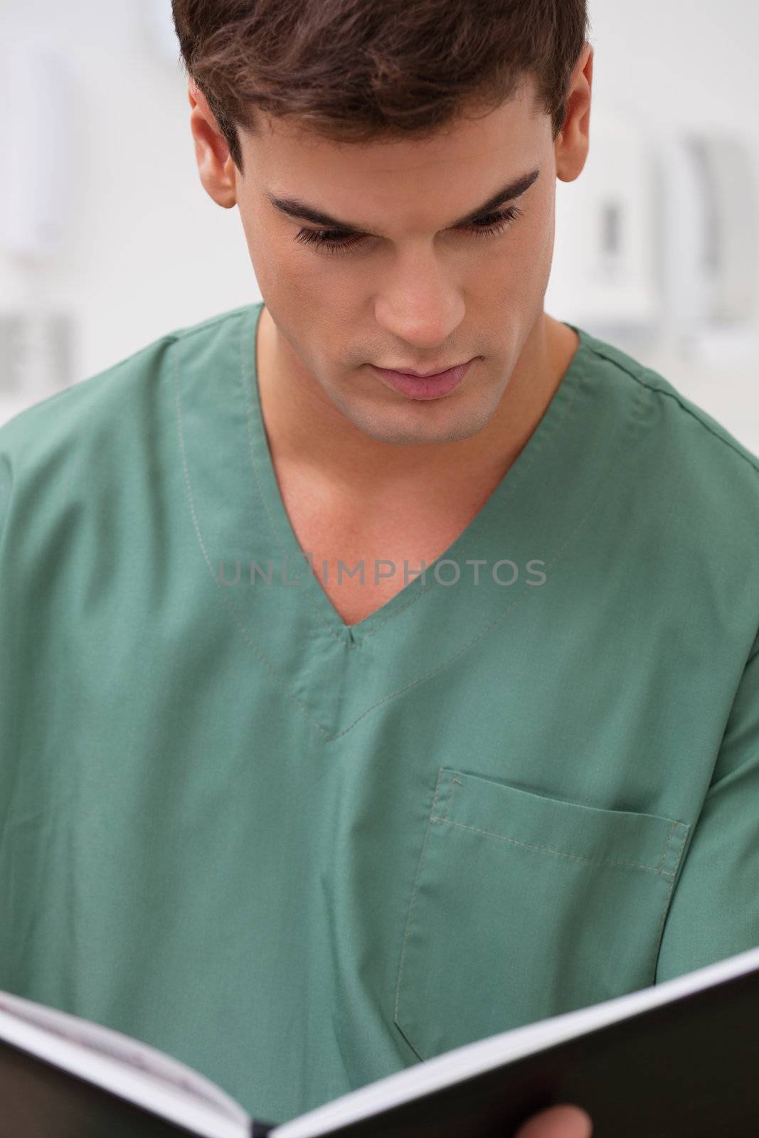 Male practitioner reading something in book