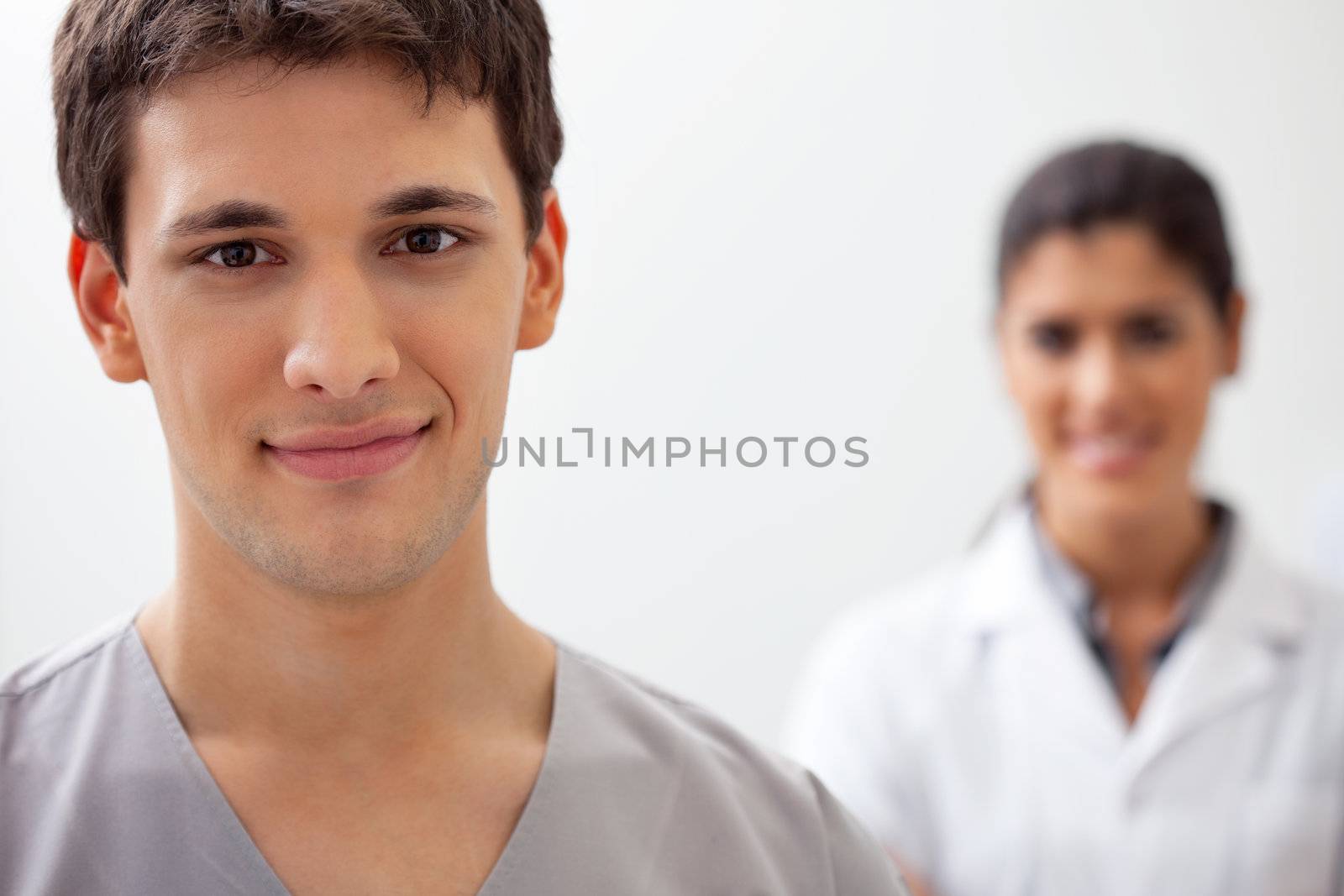 Portrait of male doctor standing with female doctor standing in background