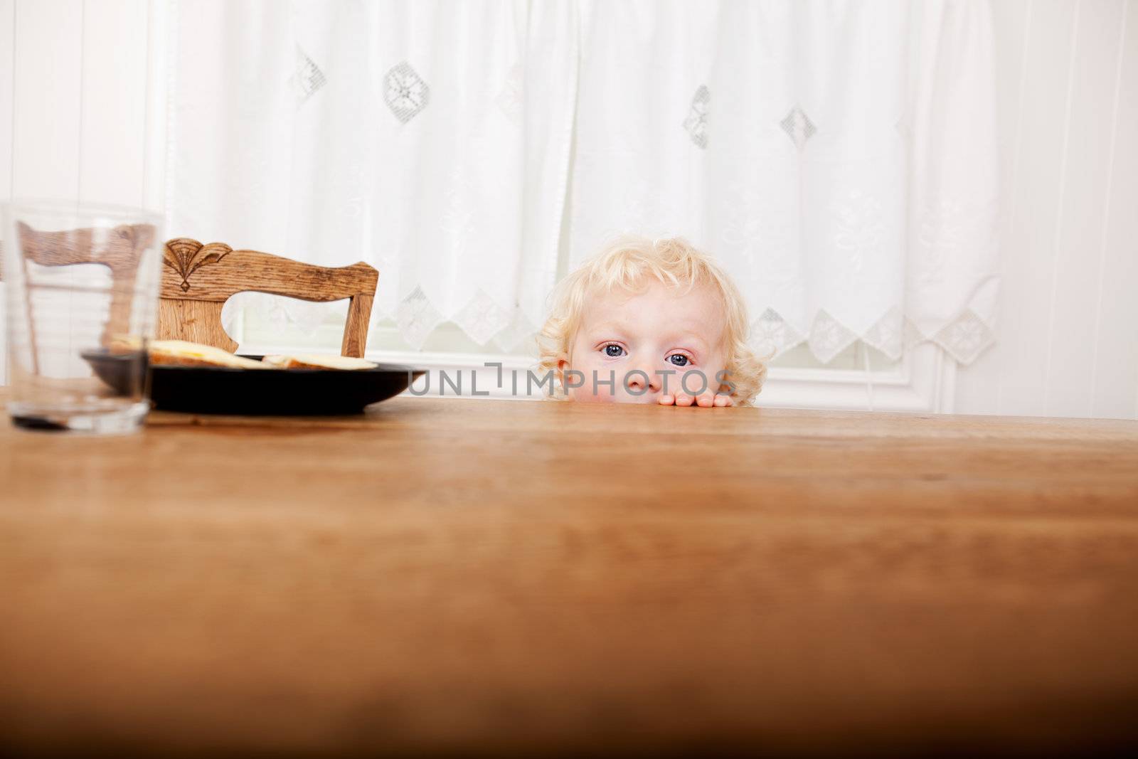 Child Peeking Over Table by leaf