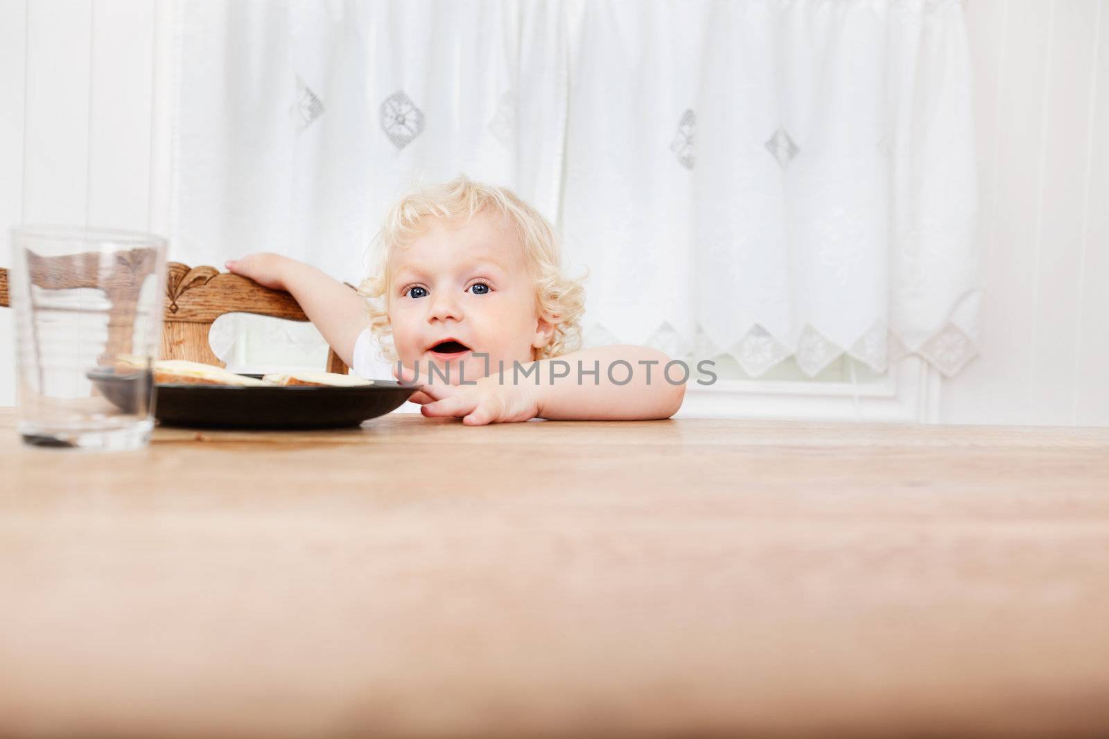 Cute adorable baby reaching for food on table