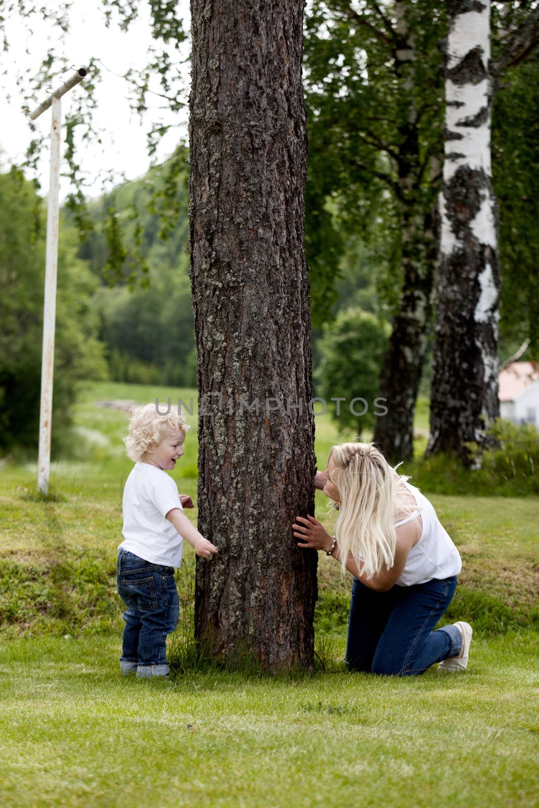 Mother and son playing hide and seek outdoors in a rural setting