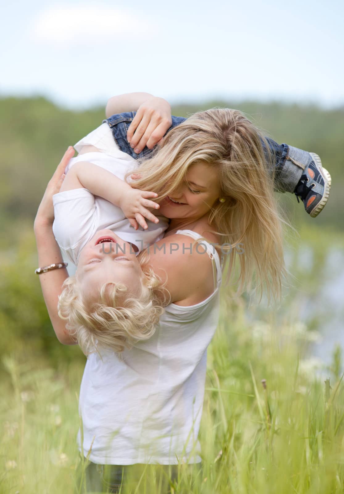 Mother and Son Playing in Meadow by leaf