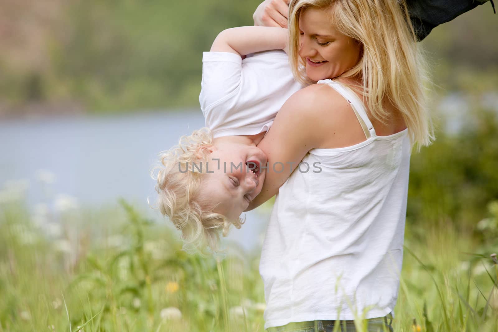 Mother and Son Playing in Meadow by leaf