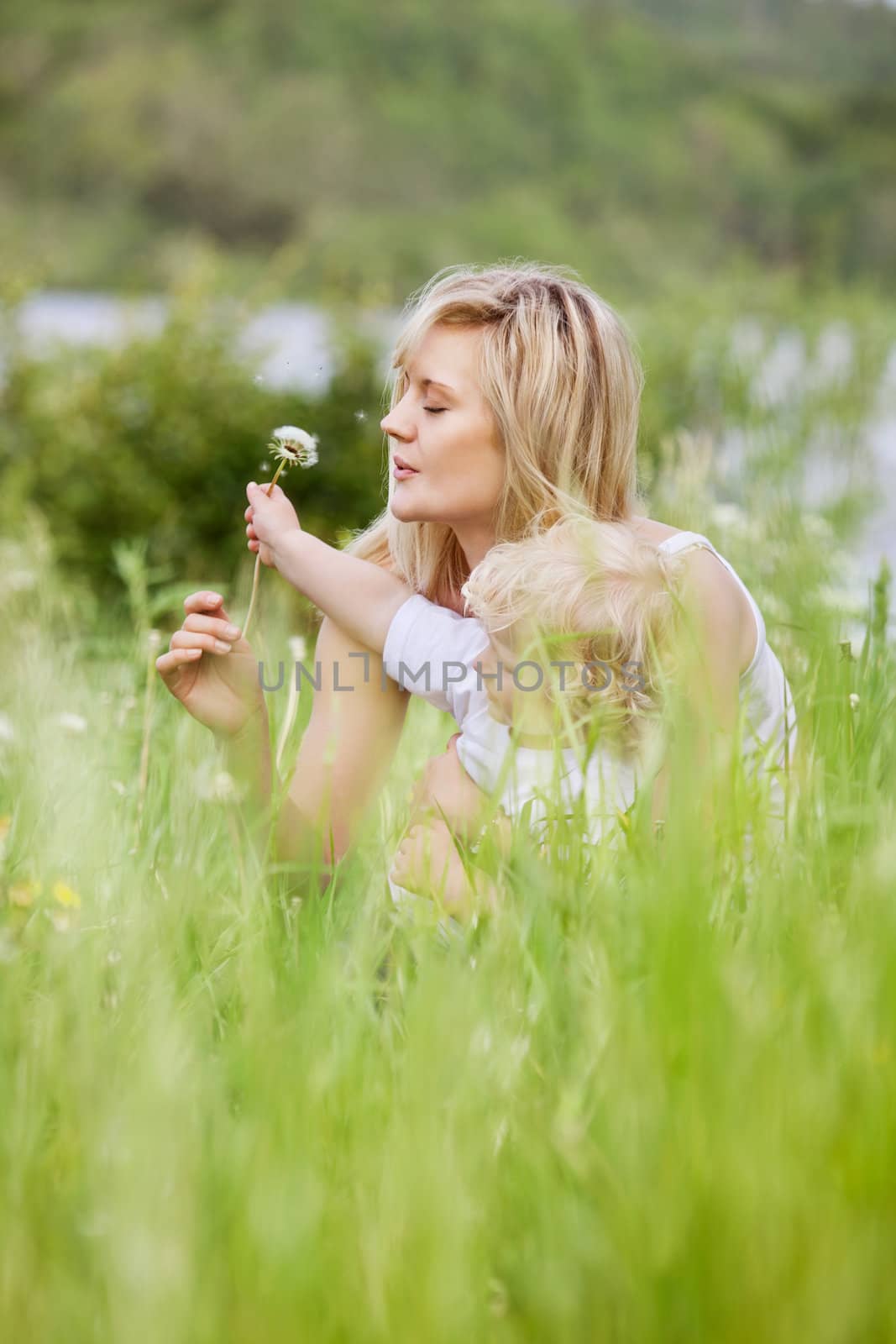 Mother and Son in Meadow Making Wishes by leaf