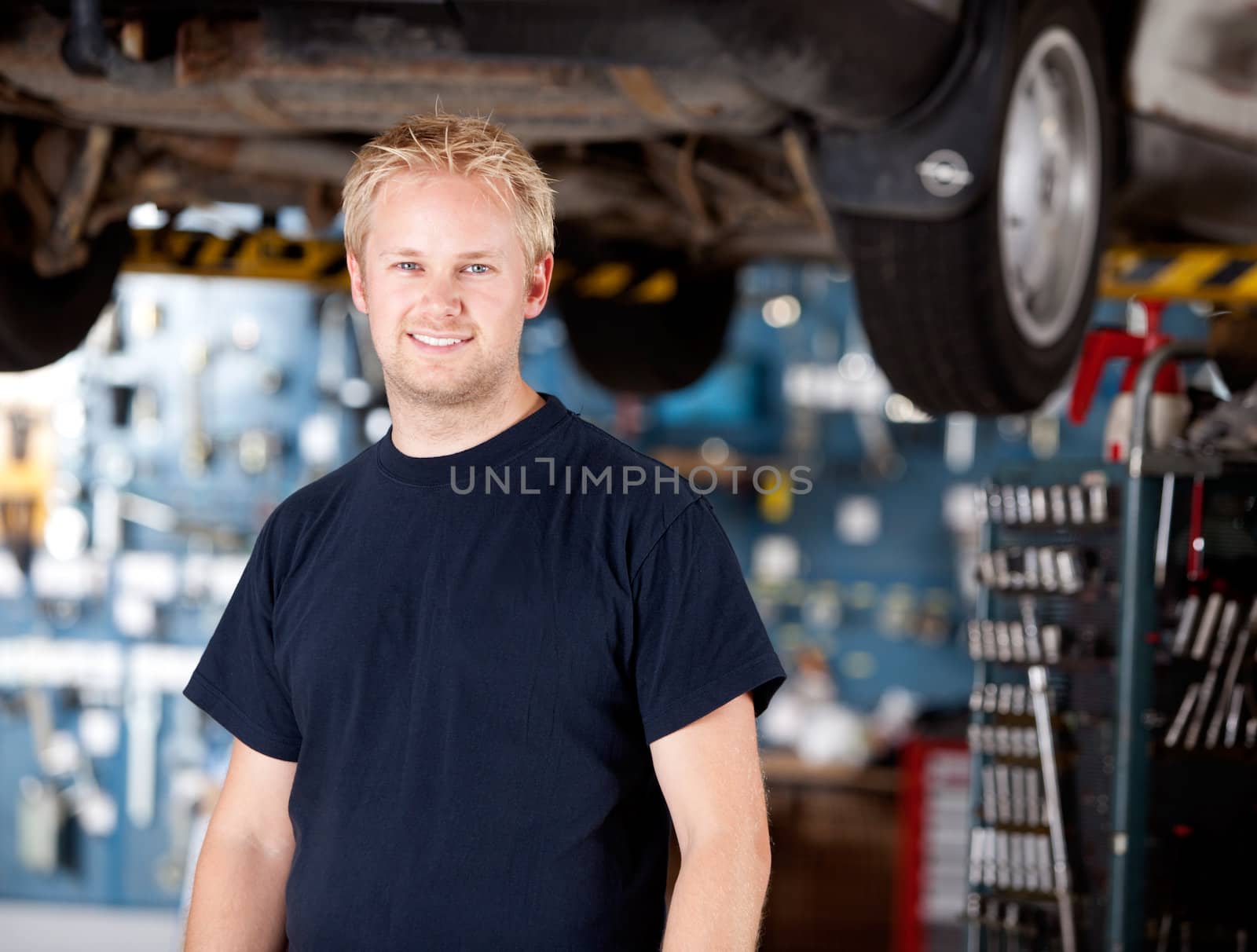 Portrait of a happy mchanic looking at the camera in garage