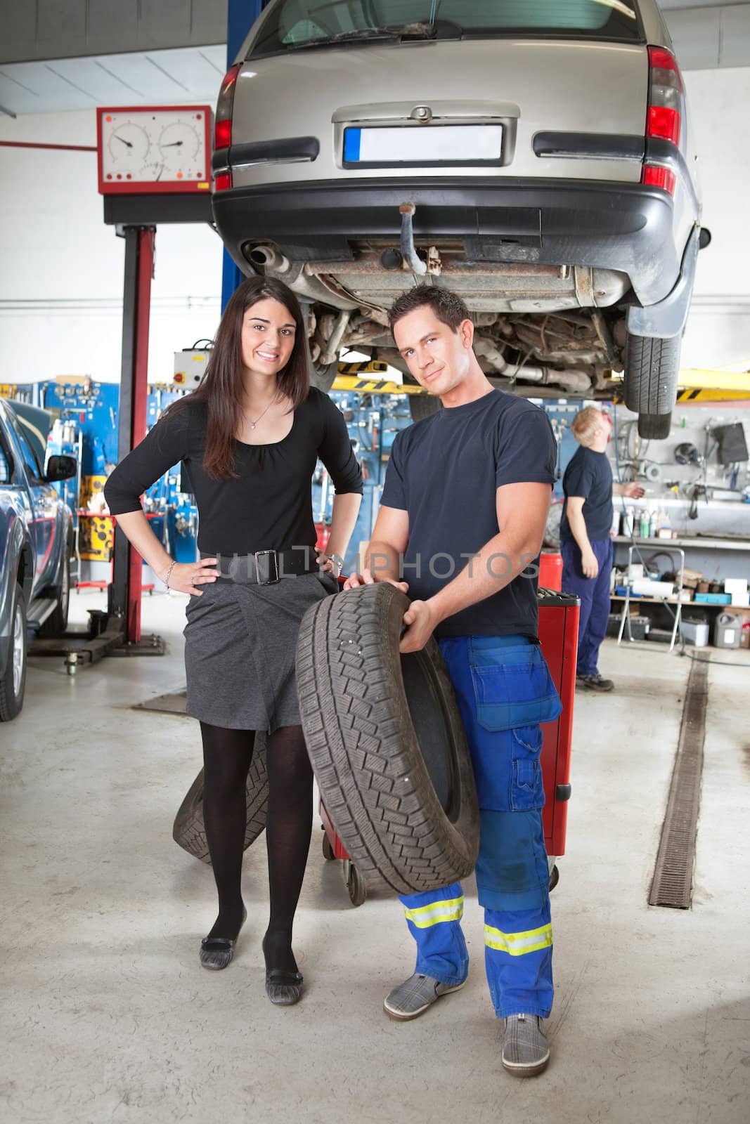 Mechanic Showing Tire to Customer by leaf