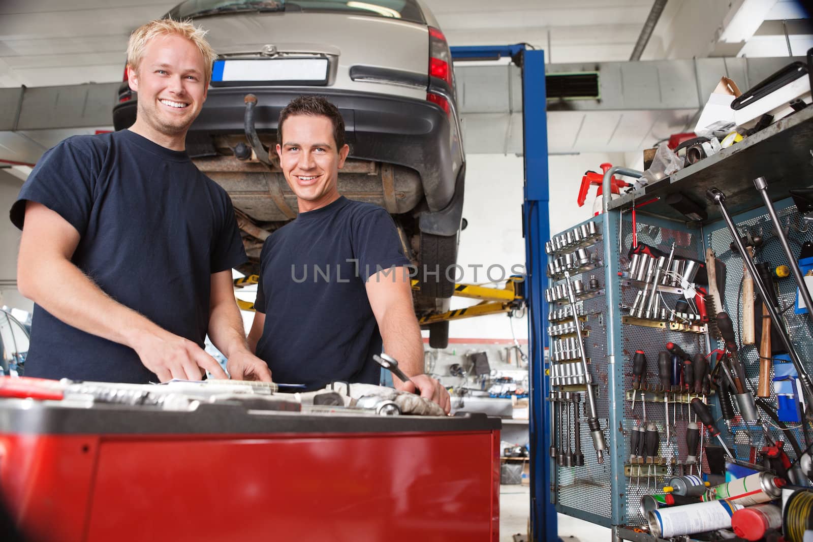 Two happy mechanics standing in garage