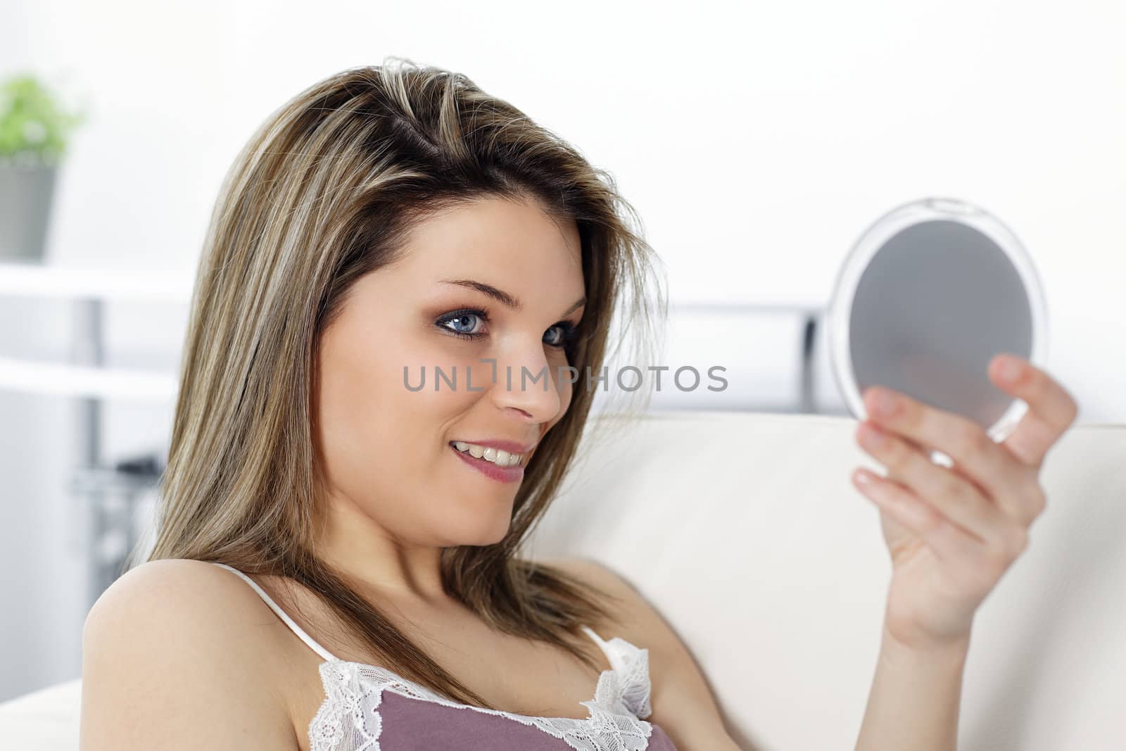 young beautiful woman looking in a  mirror