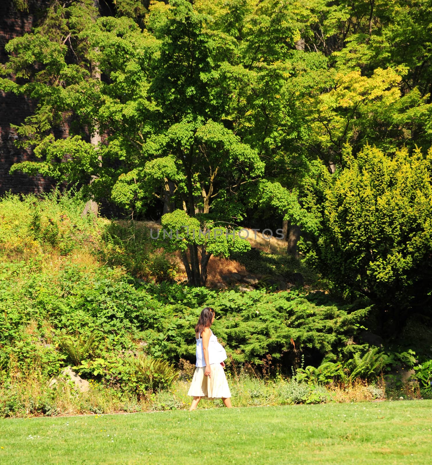 Pregnant woman walking in a public park.