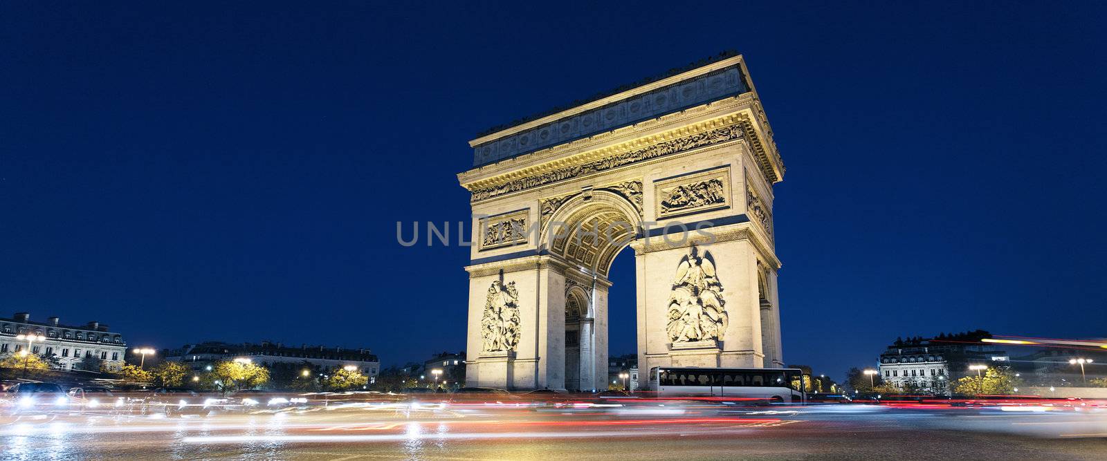 Panoramic view of Arc de Triomphe by night xith car lights