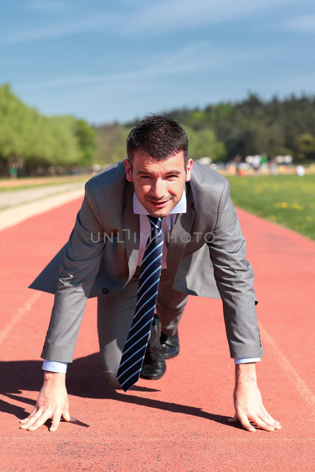 handsome businessman on a running track in summer