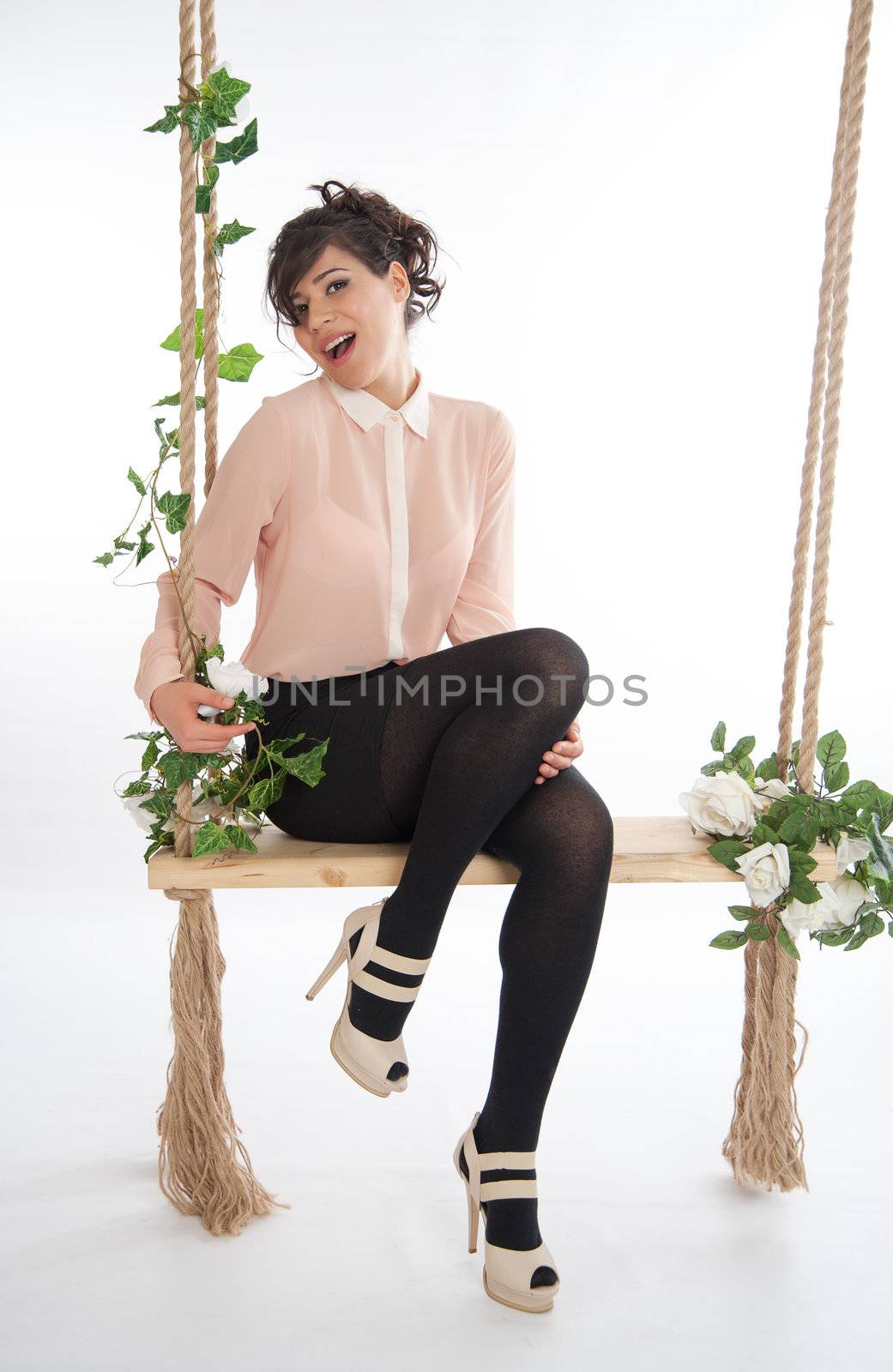 Emotional woman on a swing in the studio isolated background