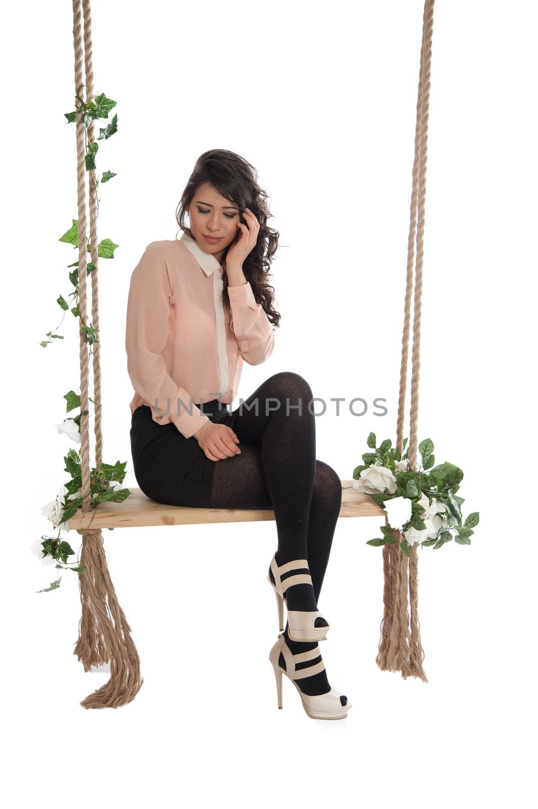 Emotional woman on a swing in the studio isolated background