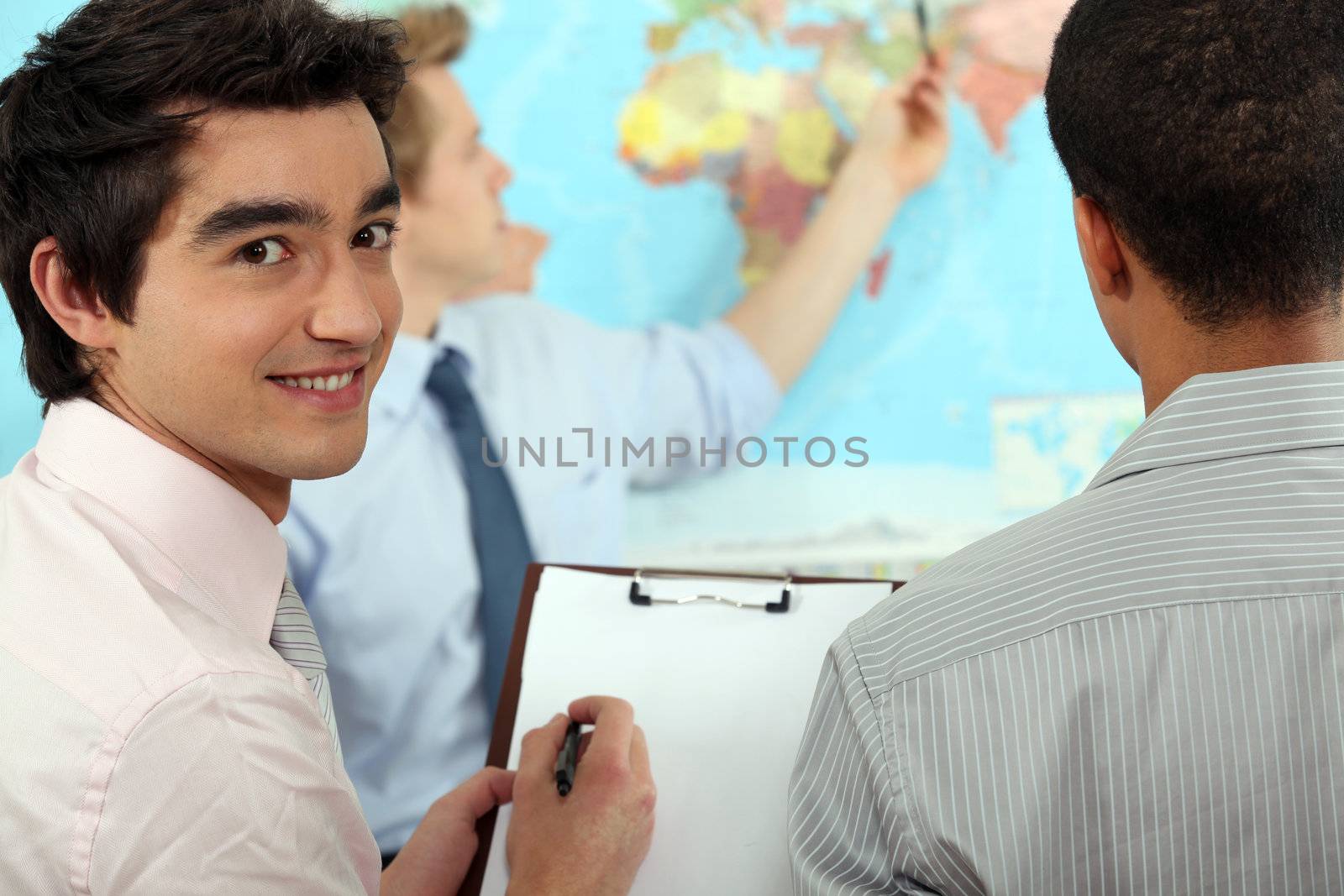 Young businessman discussing a map by phovoir