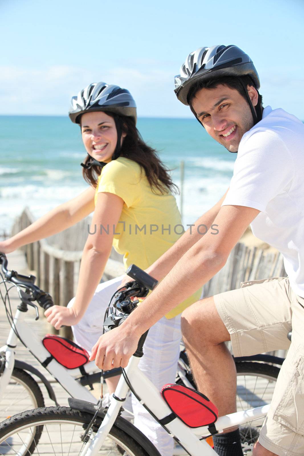 Young man and young woman having bike ride by phovoir