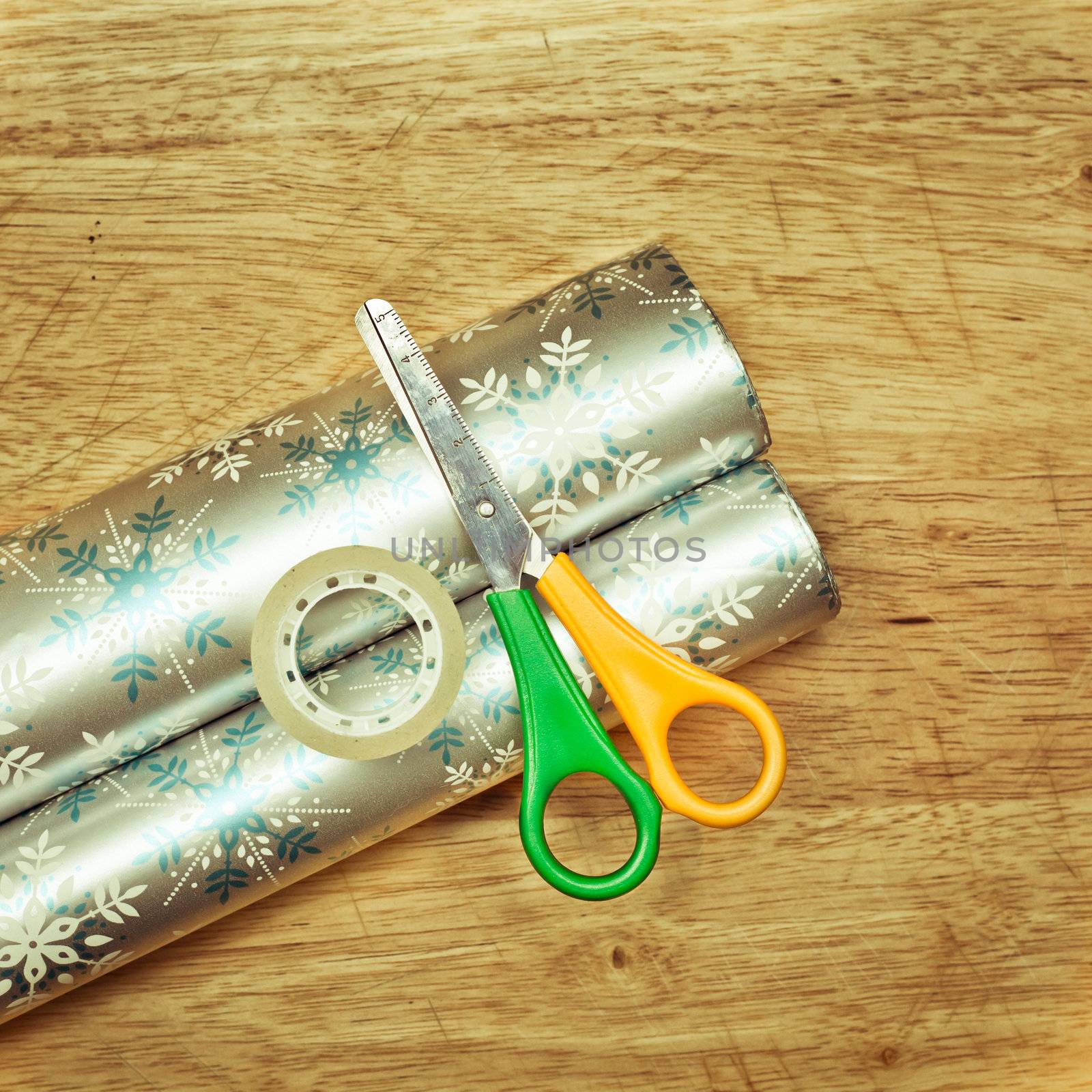 Scissors, tape and wrapping paper on a wooden table