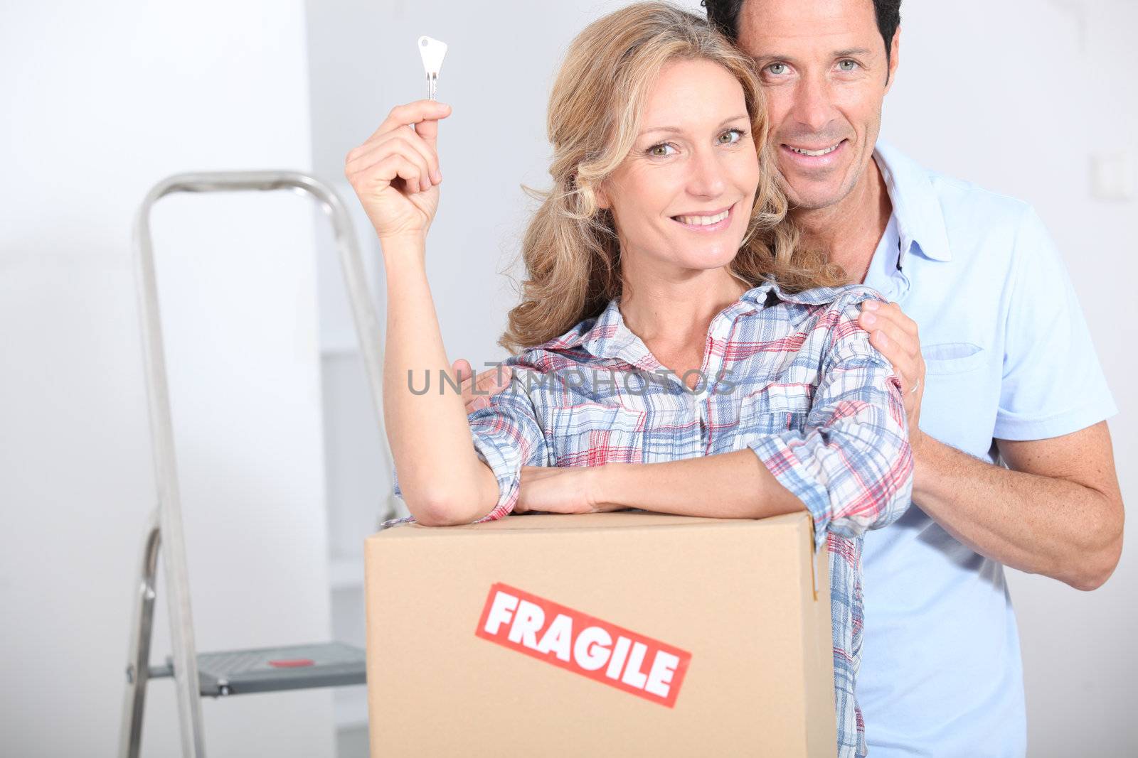 Couple stood by packing boxes by phovoir
