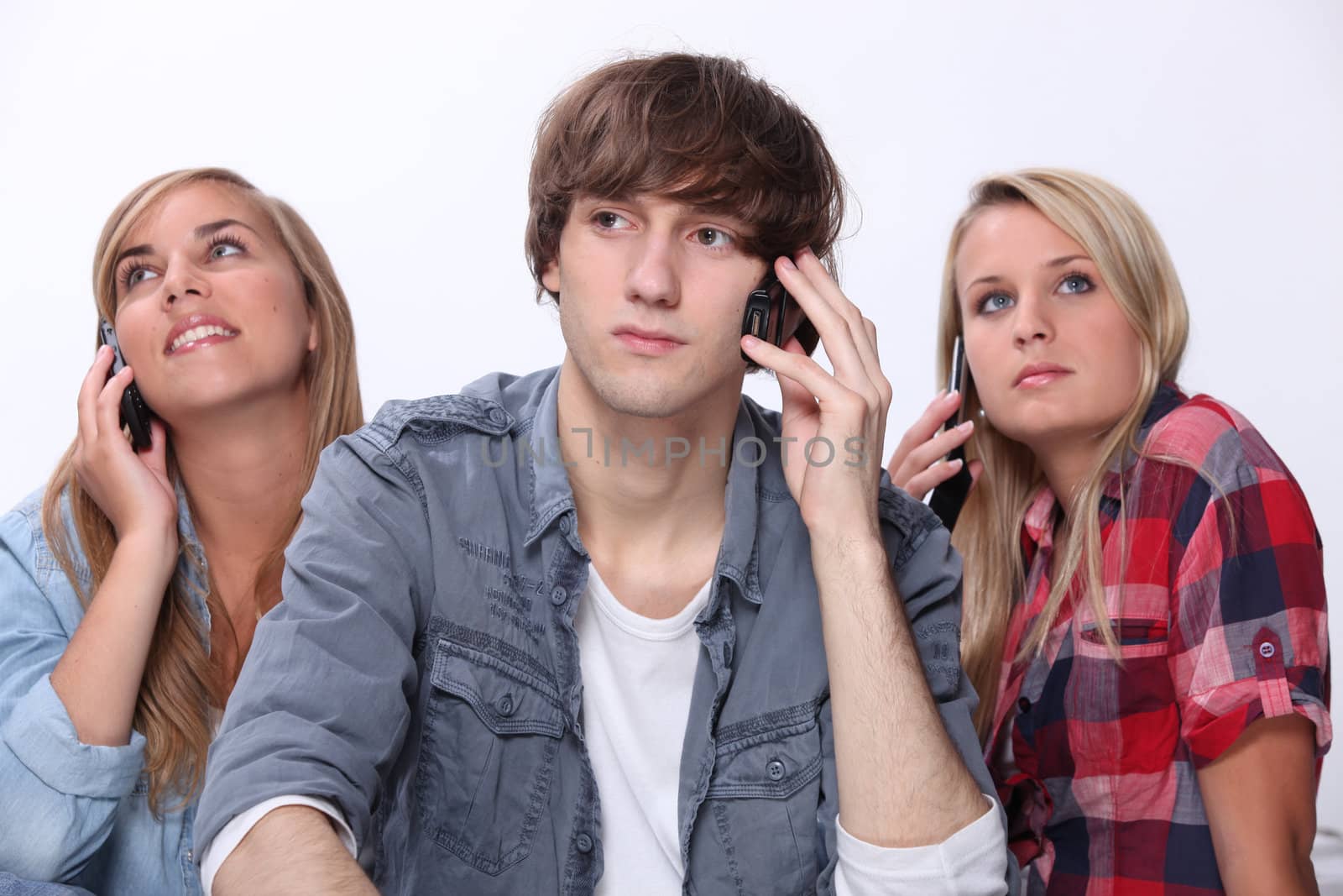 Three teenager using mobile telephones
