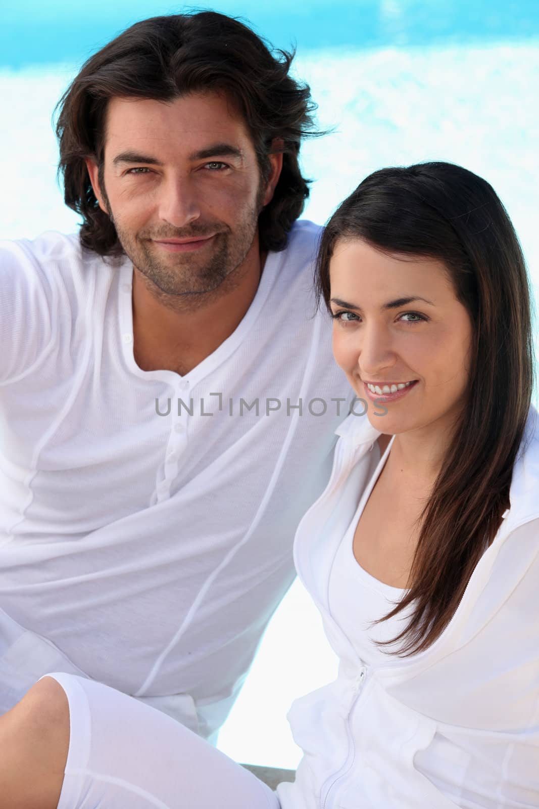 Couple wearing white next to a pool