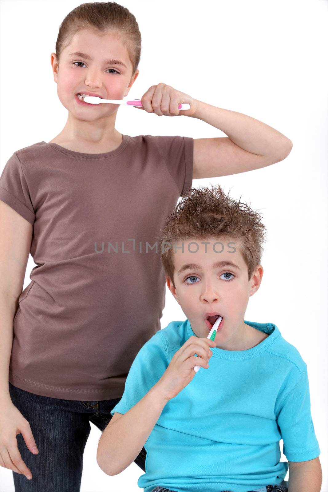 little boy and girl brushing their teeth