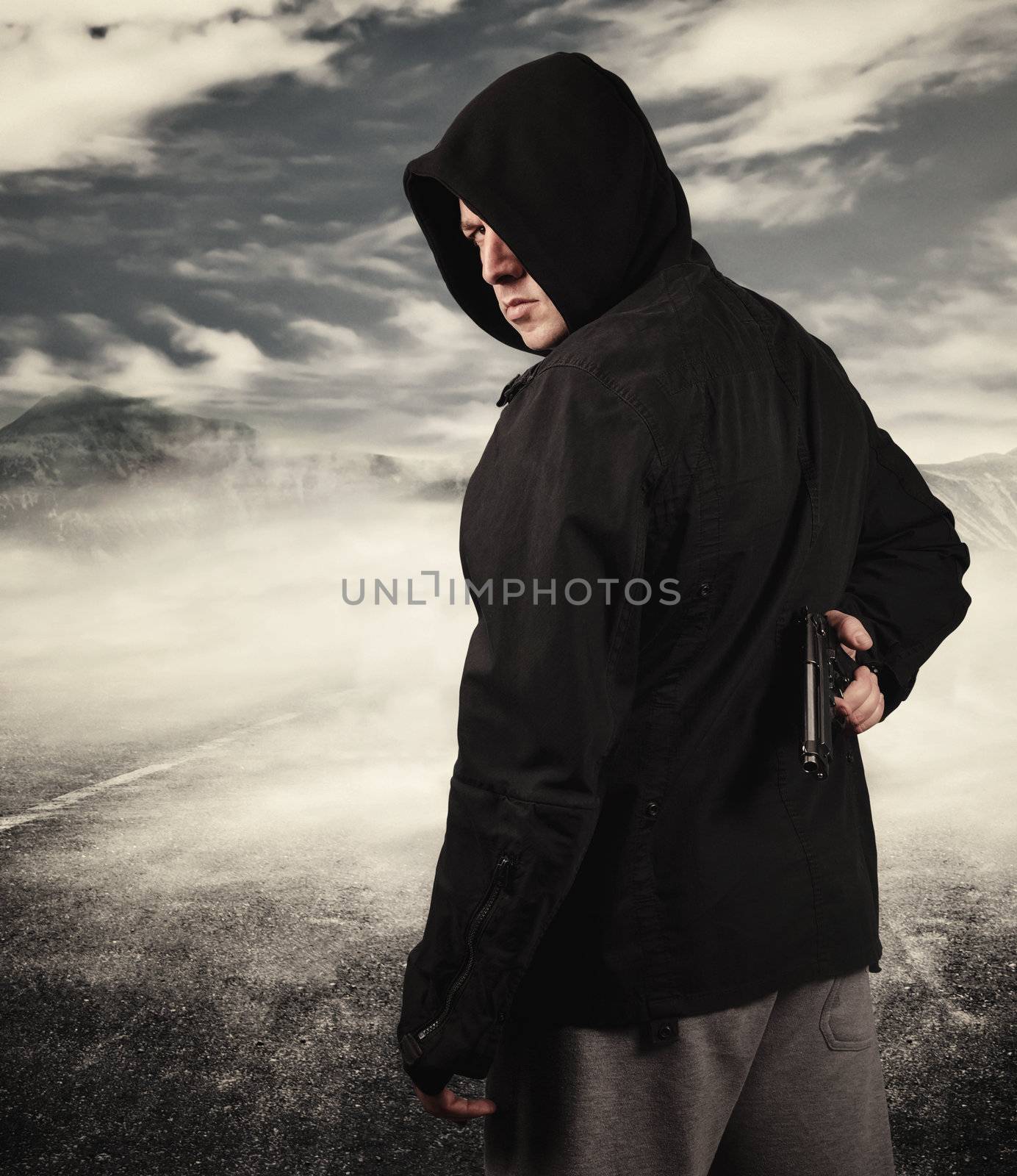 High contrast image of a teen male holding modern handgun