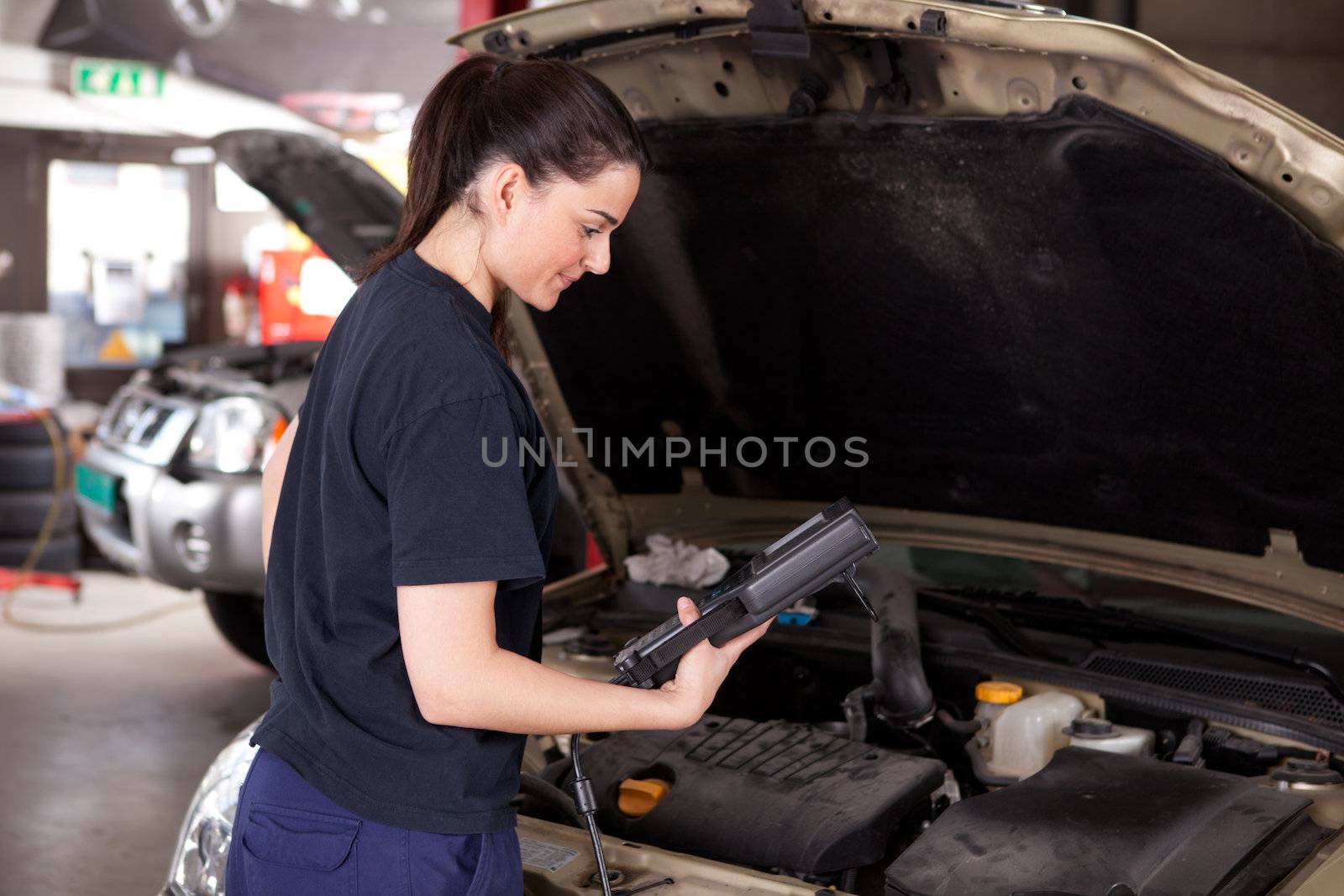 Woman Mechanic with Diagnostics Tool by leaf