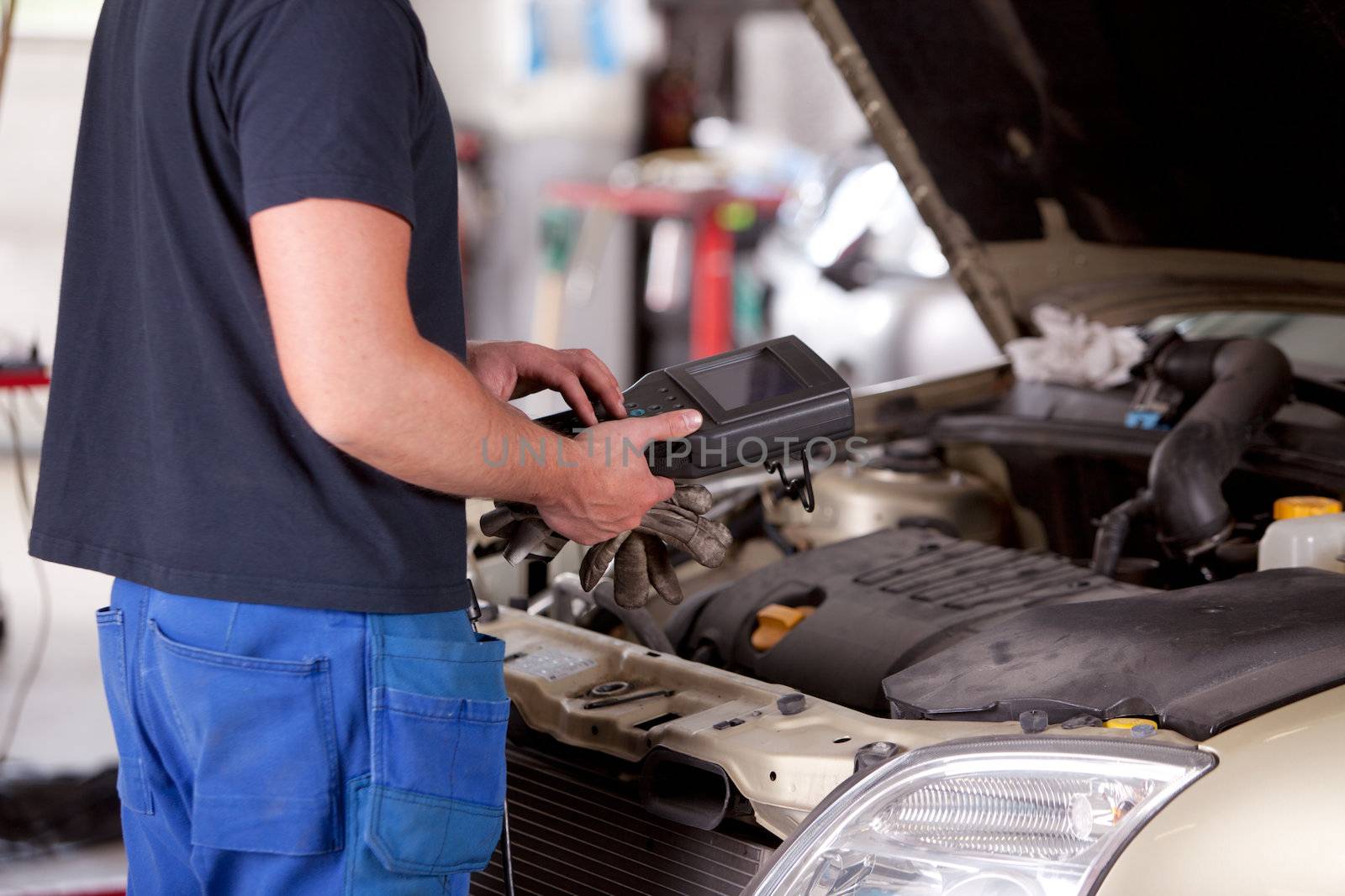 Detail of a mechanic using electrnoic diagnostic equipment to tune a car