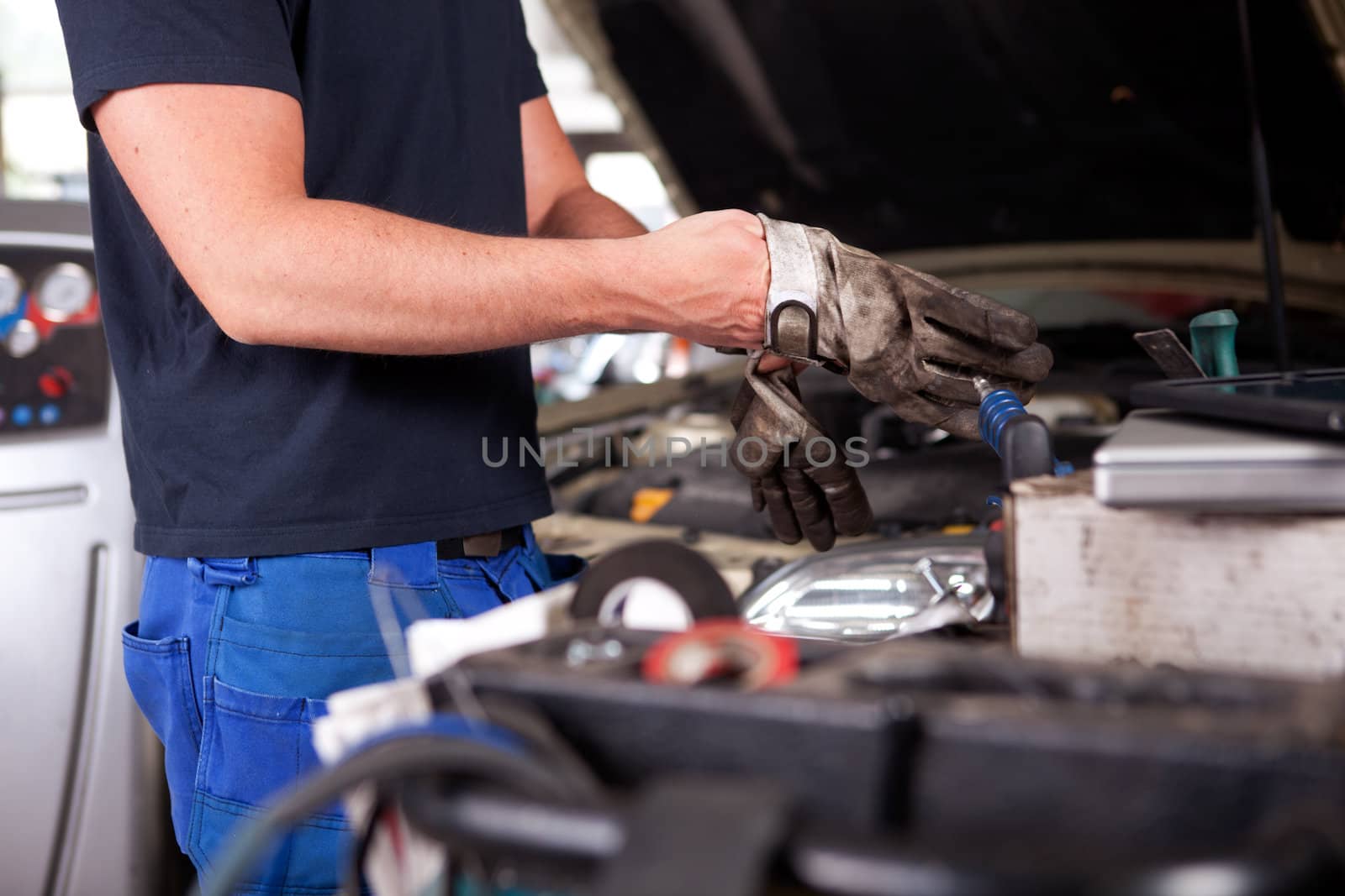 Detail of a mechanic putting on dirty work gloves