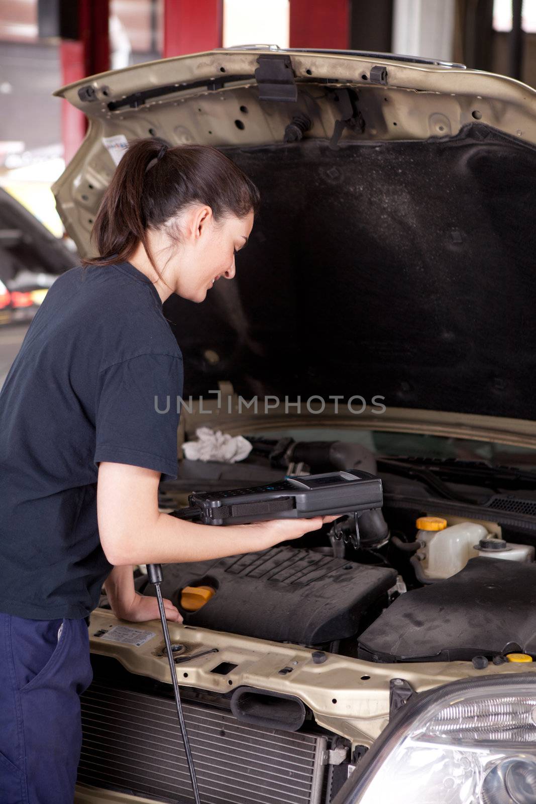 Woman Mechanic with Engine Diagnostics Tool by leaf