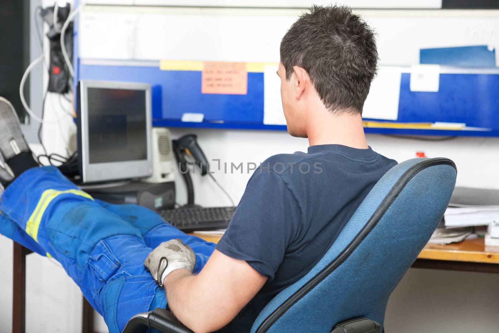 Mechanic sitting at desk in auto repair shop