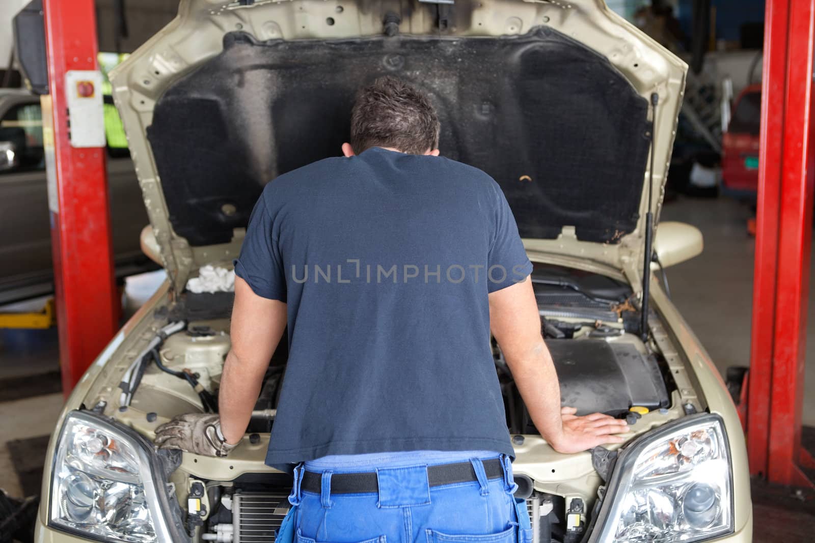 Mechanic working on a car by leaf