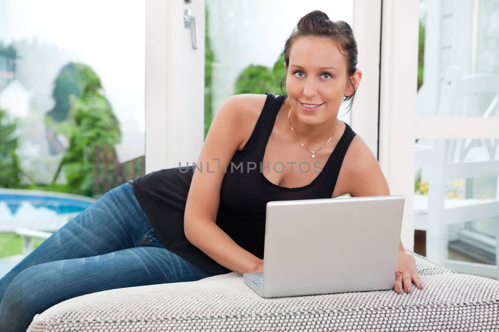 Portrait of woman using laptop by leaf