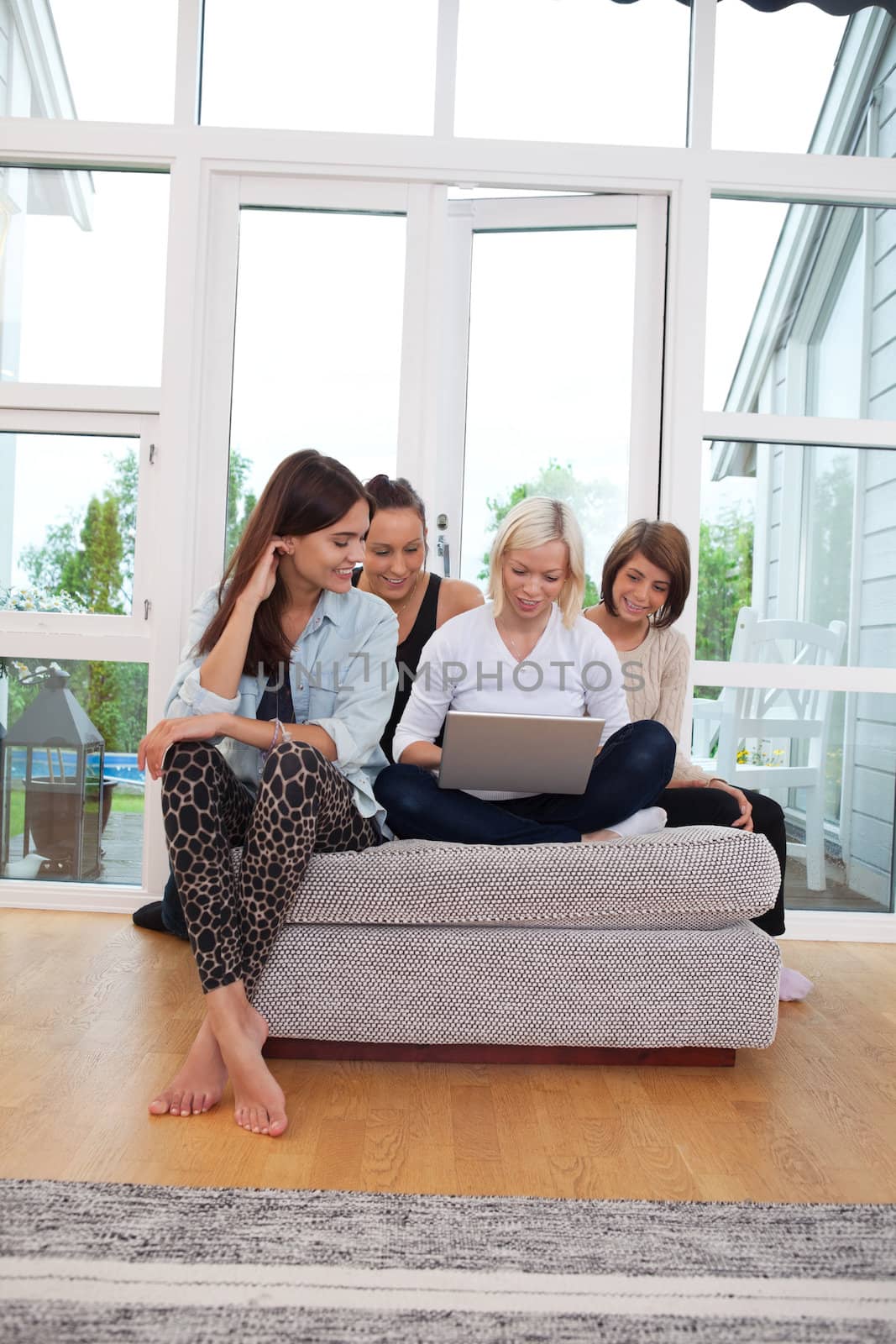 Group of female friends using laptop at home
