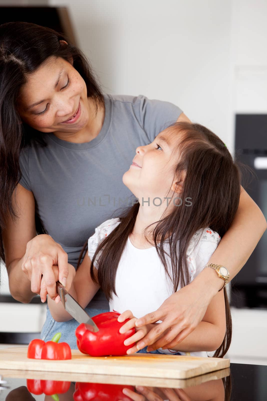 Mother and daughter cutting vegetables together