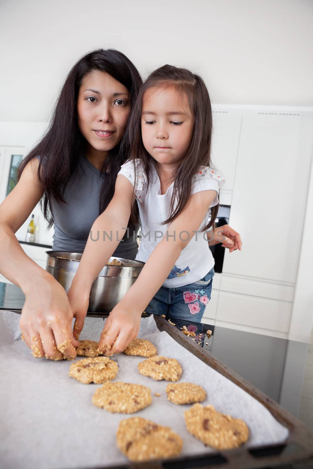 Portrait of mother and child in kitchen making cookies