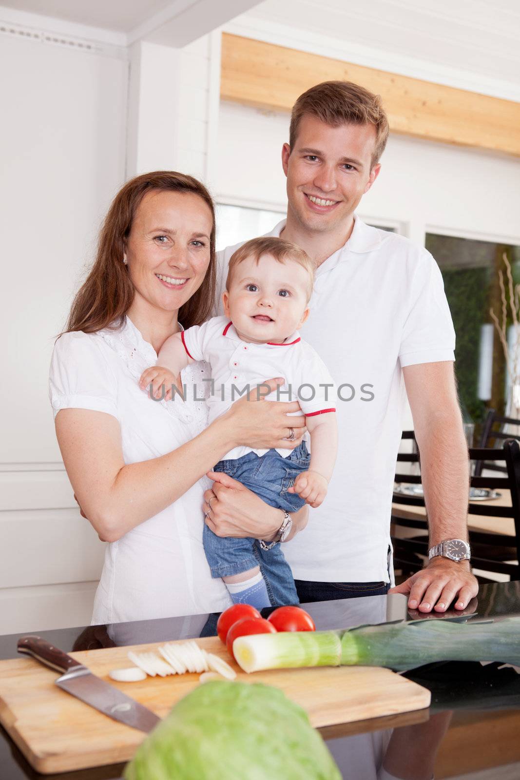 Portrait of a happy young family at home in the kitchen