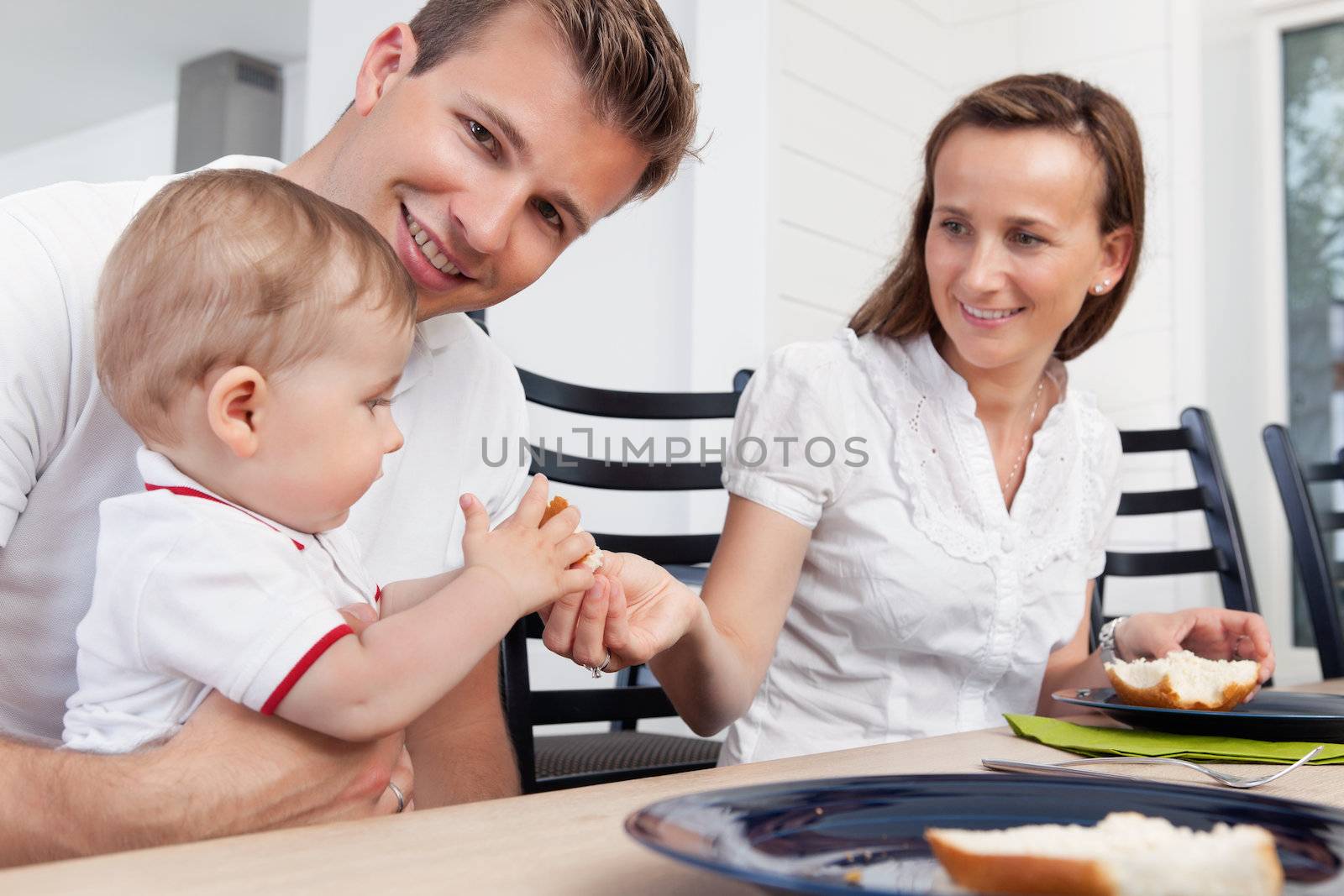 Family sitting at breakfast table by leaf