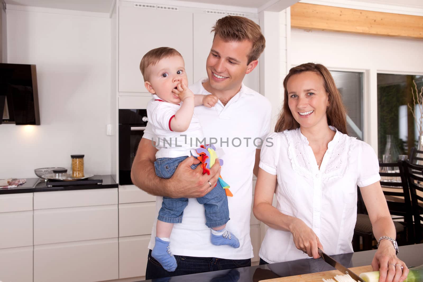Mother preparing food with father and son standing beside smiling